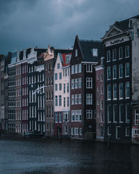 The unique houses of damrak on a cloudy day found in the heart of the dutch capital of amsterdam.