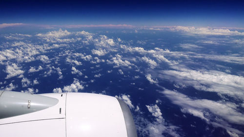 Aerial view of airplane wing over clouds