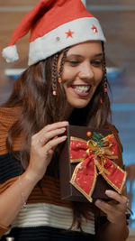 Smiling young woman holding christmas gift