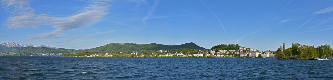 Scenic view of sea by buildings against sky