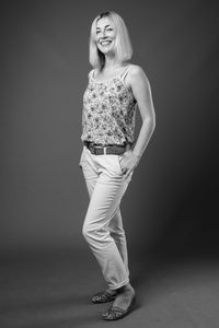 Full length of woman standing against black background