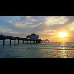 Pier on sea at sunset