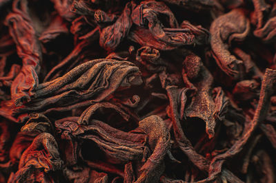 Black loose leaf tea on a red light as a background. texture of dry black tea leaves. dark