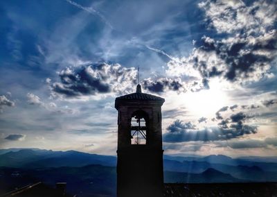 Low angle view of clock tower amidst buildings against sky