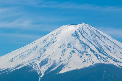 Scenic view of snowcapped mountains against cloudy sky