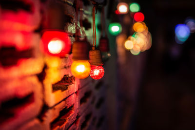 Close-up of illuminated lighting equipment hanging at night