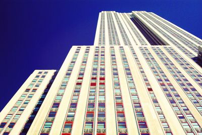 Low angle view of modern buildings against clear blue sky