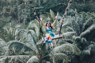 Young pretty asian woman is swinging on the cliff of the jungle in ubud, bali.