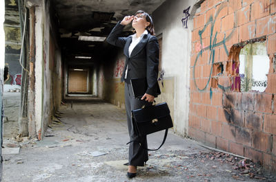 Businesswoman standing at abandoned building