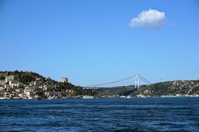 Bridge over sea and buildings against sky