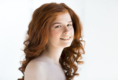 Portrait of smiling woman against white background