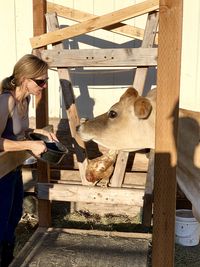 Woman standing by cow