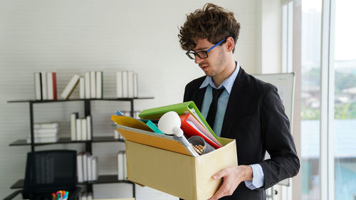 Young man holding camera in box