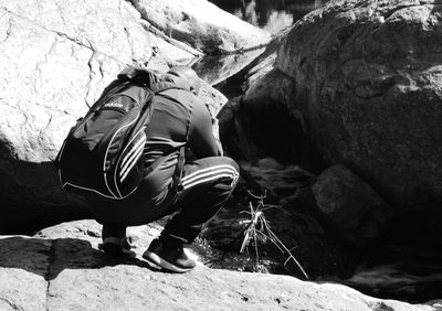 Rear view of woman standing on rock