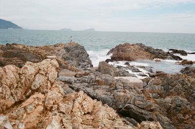 Rocks on beach against sky