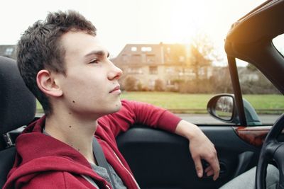 Close-up of young man sitting in car