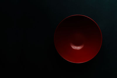 Close-up of red moon against black background