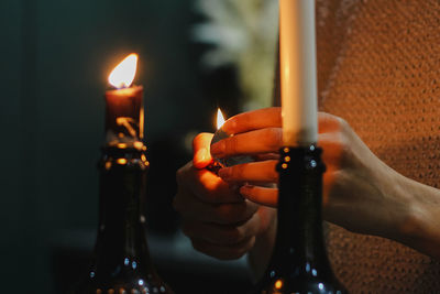 Close-up of hand holding lit candles