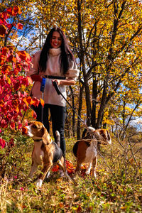 Portrait of young woman with dogs on field