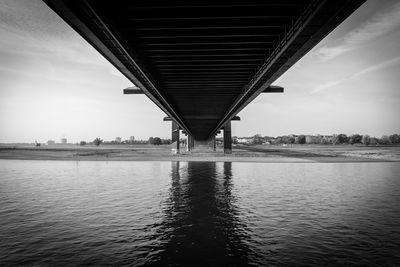 Low angle view of bridge over river against sky