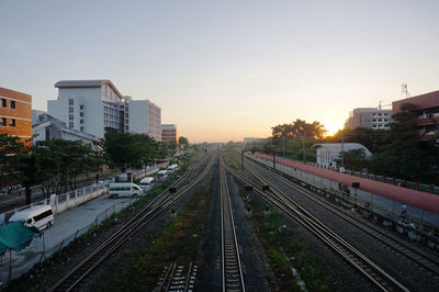 Railway tracks in city against clear sky
