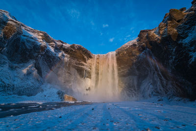 Scenic view of waterfall against sky