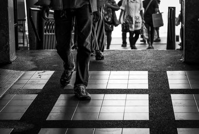 Low section of people walking on tiled floor