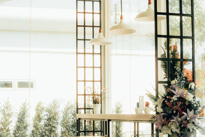 Flower vase on table by window at home