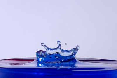 Close-up of water splashing against blue background