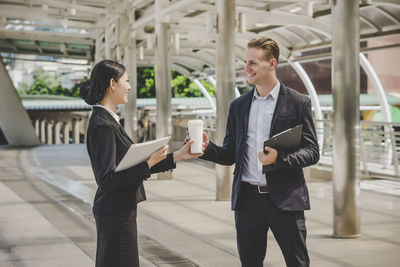 Colleagues talking while standing outdoors