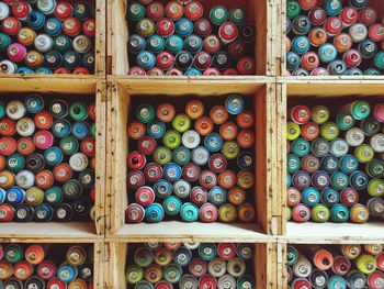 Full frame shot of colorful thread spools in wooden containers