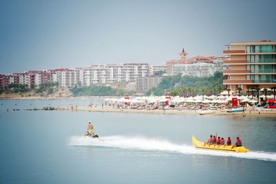 People on boat in sea against clear sky