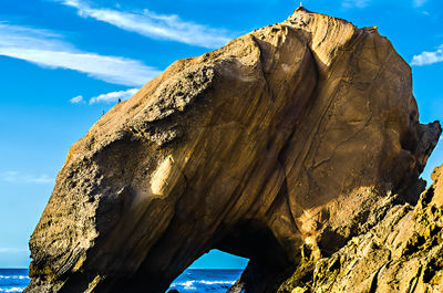 Scenic view of rock formation in sea against sky