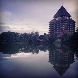 Reflection of building in lake against sky