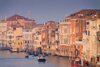 Boats in canal amidst buildings in city