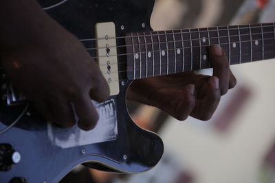 Close-up of man playing guitar