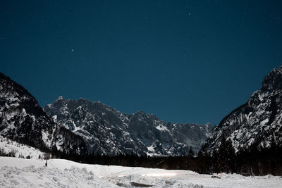 Scenic view of snowcapped mountains against sky at night