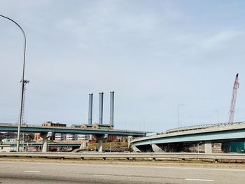 Bridge over road against sky in city