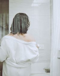 Reflection of woman standing in bathroom