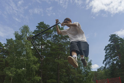 The boy performs extreme stunts jumping with a scooter, extreme sports, jumping in the air