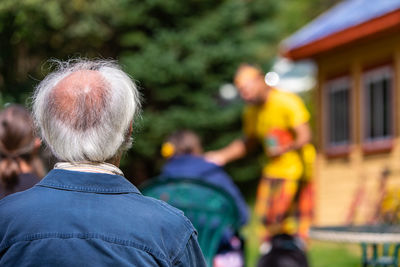 Rear view of people against blurred background