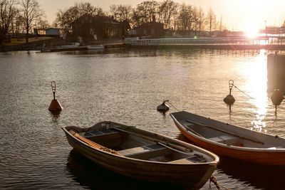 Boats in sea at sunset