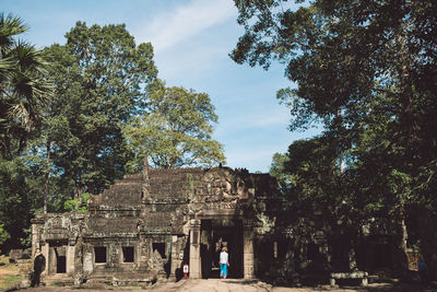 Rear view of mid adult woman walking at ankor wat temple