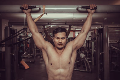 Shirtless muscular man exercising at gym