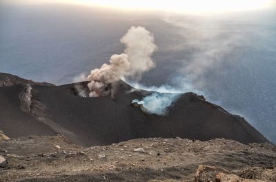 Smoke emitting from volcanic mountain against sky