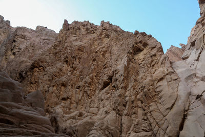 Low angle view of rocky mountains against sky