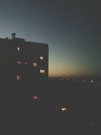 Illuminated building against sky at dusk