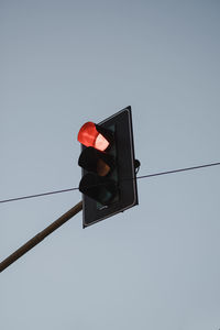 Low angle view of road signal against clear sky