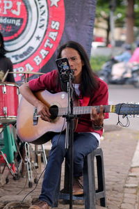 Man playing guitar on the side road