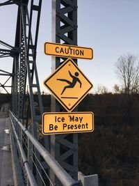 Close-up of road sign against sky